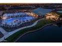 Aerial view of the community pool area featuring multiple pools, seating, and a pond at 26047 S 228Th Pl, Queen Creek, AZ 85142