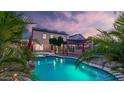 Lush backyard featuring a sparkling pool, a pergola, mature landscaping, and solar panels at 28021 N 23Rd Dr, Phoenix, AZ 85085
