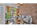 Inviting living room with a rustic brick wall, arched windows, and stylish decor at 28021 N 23Rd Dr, Phoenix, AZ 85085