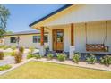 Inviting front porch with a swing and beautifully landscaped yard at 3651 N 49Th Pl, Phoenix, AZ 85018