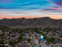 Wide aerial view of residential area with mountain backdrop and colorful sunset sky at 4252 E Zia St, Phoenix, AZ 85044
