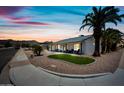 Attractive single-story home with desert landscaping, lush lawn, and sunset sky at 4252 E Zia St, Phoenix, AZ 85044
