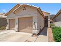 This home's exterior is nicely maintained, with a two-car garage and beautiful desert-style landscaping at 4918 W Wahalla Ln, Glendale, AZ 85308