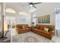 Bright living room featuring tile flooring, leather sofas, and a ceiling fan at 4918 W Wahalla Ln, Glendale, AZ 85308