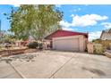 Home exterior featuring an attached garage, mature landscaping, and a concrete driveway at 5140 N 69Th Ave, Glendale, AZ 85303