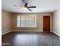 Comfortable living room with laminated wood floors, ceiling fan, light-colored walls and a large window at 5414 E Albany St, Mesa, AZ 85205