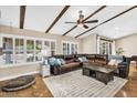 Spacious living room features beamed ceilings, large windows, plantation shutters and a large leather sofa at 6352 W Hackamore Dr, Phoenix, AZ 85083