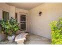 Cozy entryway with a decorative bench, unique wrought iron door, and lush plants at 6717 E Aire Libre Ln, Scottsdale, AZ 85254