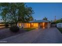Inviting single-story home with a spacious driveway and mature trees enhancing its curb appeal at 7035 N 11Th Pl, Phoenix, AZ 85020