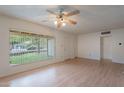 Bright living room with wood floors, large windows, and a classic ceiling fan at 7035 N 11Th Pl, Phoenix, AZ 85020