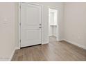 Hallway with tiled floors leading to a walk-in closet and a white door at 7428 S 75Th Ln, Laveen, AZ 85339