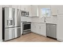 Modern kitchen with stainless steel appliances, white cabinets, and tiled backsplash at 7428 S 75Th Ln, Laveen, AZ 85339