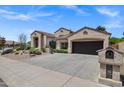 Attractive home features desert landscaping, a two-car garage, and a private mailbox at 10310 N 135Th Way, Scottsdale, AZ 85259