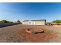 Spacious lot with a charming single-story home, gravel landscaping, and brick firepit, ideal for outdoor enjoyment at 10618 W Prairie Ln, Casa Grande, AZ 85193