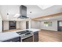 Open-concept living space with a modern kitchen, sleek range hood, and hardwood floors throughout at 12431 N 30Th Ave, Phoenix, AZ 85029