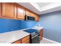 A modern kitchen featuring ample counter space, updated appliances, and classic wood cabinets at 1402 E Guadalupe Rd # 207, Tempe, AZ 85283
