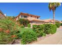 Charming two-story home with a terra cotta roof, flowering bushes, and manicured lawn at 1575 S Pennington Dr, Chandler, AZ 85286