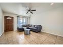 Comfortable living room featuring tile floors, fan and a cozy sectional couch at 17232 N 29Th Ave, Phoenix, AZ 85053