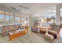 Bright living room with ceiling fan, plantation shutters and seamless flow to the kitchen at 19662 N Overton Ct, Surprise, AZ 85374