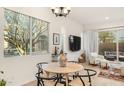 Comfortable dining area featuring modern light fixture and view to backyard, adjacent to the open-concept living area at 23083 N 74Th Pl, Scottsdale, AZ 85255