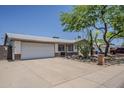 Single story home with mature landscaping and a two-car garage offering curb appeal at 2432 W Echo Ln, Phoenix, AZ 85021