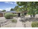 Charming front yard with lush landscaping, decorative rock features, and a welcoming walkway to the entrance at 3018 E Mulberry Dr, Phoenix, AZ 85016