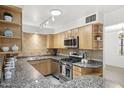 Well-appointed kitchen featuring granite countertops, stainless steel appliances, and stylish wood cabinetry at 3018 E Mulberry Dr, Phoenix, AZ 85016