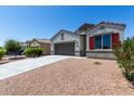 Attractive single-story house with desert landscaping, two-car garage and a blue sky at 30938 W Mitchell Dr, Buckeye, AZ 85396
