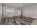 Bright living room boasts stylish wood-look floors, a ceiling fan, and natural light at 30938 W Mitchell Dr, Buckeye, AZ 85396