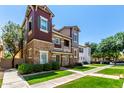 Eye-level view of a multi-story townhome with stone accents and green grass at 4072 E Windsor Dr, Gilbert, AZ 85296