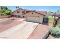 View of the home's side, a long driveway, garage, and view of pool in backyard at 4414 S Ventura Dr, Tempe, AZ 85282