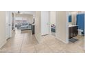 Hallway leading to living area and bathroom with light-colored tile floors and neutral-toned walls at 44232 W Palo Cedro Rd, Maricopa, AZ 85138