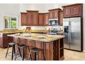 Close up of kitchen with stainless steel appliances, dark wood cabinetry, and a large island with seating at 4684 W Tyson St, Chandler, AZ 85226
