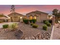 Beautifully landscaped front yard with desert plants, river rock, and mature trees enhancing the curb appeal of this desert home at 6648 S Lyon Dr, Gilbert, AZ 85298