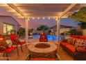 Inviting outdoor space with a fire pit, comfortable seating, a covered patio, and a beautiful pool for relaxation and entertainment at 6648 S Lyon Dr, Gilbert, AZ 85298