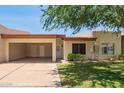 Charming single-story home featuring an open carport and well-maintained front yard landscaping at 9106 N 68Th Ln, Peoria, AZ 85345