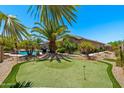 Beautiful backyard with a well manicured putting green and relaxing swimming pool at 1078 W Desert Aster Rd, San Tan Valley, AZ 85143
