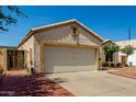 Street view of a stucco home with a two-car garage, desert landscaping and a brick-lined driveway at 11518 W Dana Ln, Avondale, AZ 85392