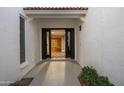 View of the front door, looking into the foyer area with hard wood flooring and decorative rug at 14029 N Burning Tree Pl, Phoenix, AZ 85022