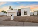 A view of the single-story home with desert landscaping, a two-car garage, and a gated entry way at 14029 N Burning Tree Pl, Phoenix, AZ 85022
