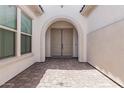 Inviting entryway with arched entry and decorative double doors, with views of the courtyard at 16981 W Cameron Dr, Surprise, AZ 85388