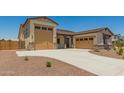 Stylish single-Gathering home featuring a three car garage, neutral color scheme, and desert landscaping at 17304 W Royal Palm Rd, Waddell, AZ 85355