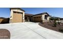 Spacious home featuring an extended driveway, desert landscaping, and tandem two-car garage at 17304 W Royal Palm Rd, Waddell, AZ 85355