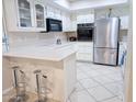 Bright kitchen featuring white cabinets, stainless steel fridge and microwave at 17404 N 99Th Ave # 126, Sun City, AZ 85373