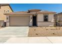 Tan single-Gathering home with a two-car garage and low-maintenance landscaping at 18354 W Patrick Ln, Surprise, AZ 85387