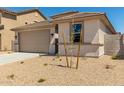 Tan single-Gathering home with a two-car garage and low-maintenance landscaping at 18354 W Patrick Ln, Surprise, AZ 85387