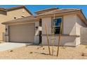 Tan single-Gathering home with a two-car garage and low-maintenance landscaping at 18354 W Patrick Ln, Surprise, AZ 85387