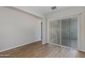 Open-concept living room featuring wood-look tile flooring, neutral walls, and a sliding glass door at 24533 N 19Th Ter, Phoenix, AZ 85024