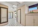 Bright enclosed sun room featuring tile flooring, multiple windows, storage, and easy access to the home's exterior at 25 N Cottonwood St # 47, Chandler, AZ 85225