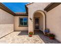 Inviting front porch with paver flooring and a decorative welcome pillow at 26161 W Siesta Ln, Buckeye, AZ 85396